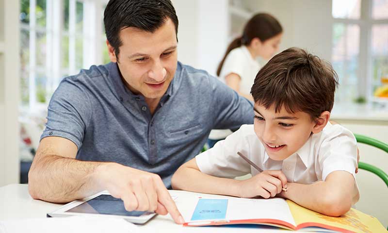 Padre ayudando a su hijo a hacer los deberes