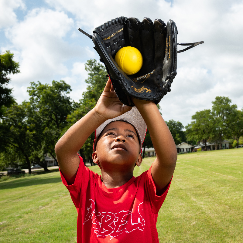 little boy catching a baseball