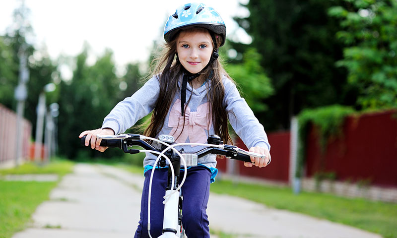 niña con casco en bicicleta