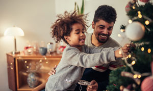 Un padre y su hija decorando el árbol de Navidad