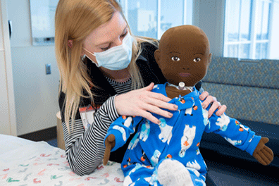 Child Live demonstrates with a doll who has a trach - Children's Health