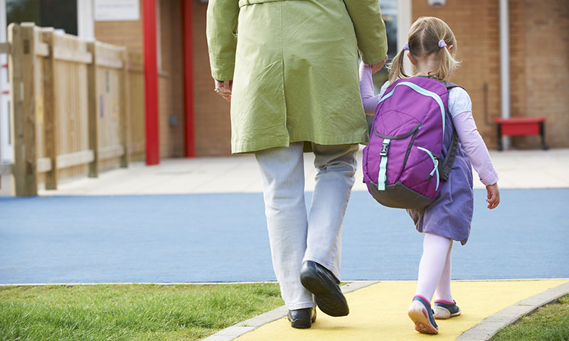 niña pequeña caminando a la escuela con su madre