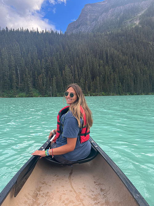 Young woman kayaking across a lake