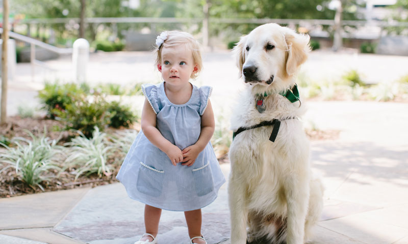 Emily standing with a service dog