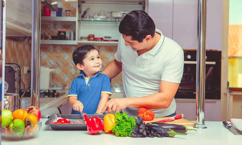 Padre e hijo pequeño cocinando juntos