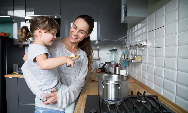 Mamá con su hija en brazos en la cocina
