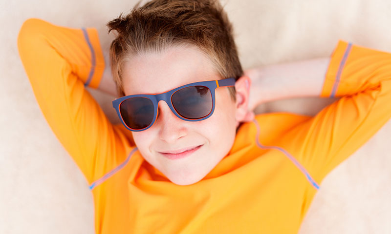 Niño pequeño con camiseta con protección solar al aire libre con gafas de sol