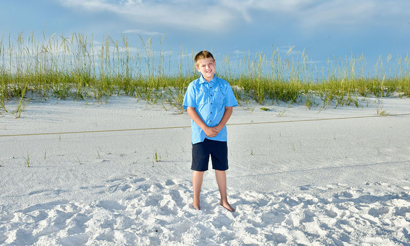 Niño posando para una foto en una playa