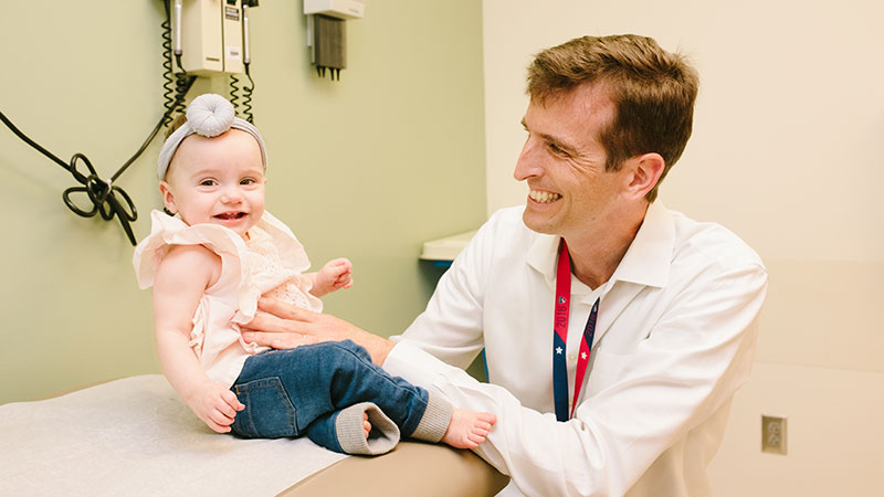 Baby smiling with physician