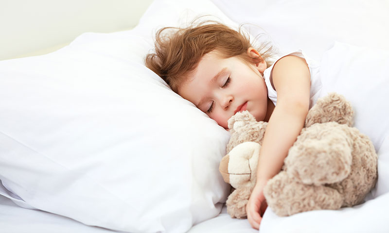 niña durmiendo con su osito de peluche