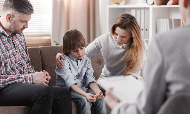 Padres y terapeutas consolando a un niño pequeño