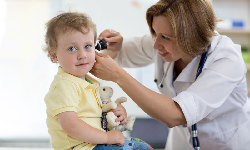 Médico controlando el oído de un niño pequeño