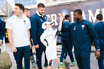 Henry con jugadores de fútbol americano de Notre Dame