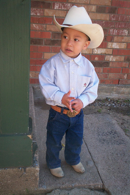Little boy wearing cowboy hat while looking away