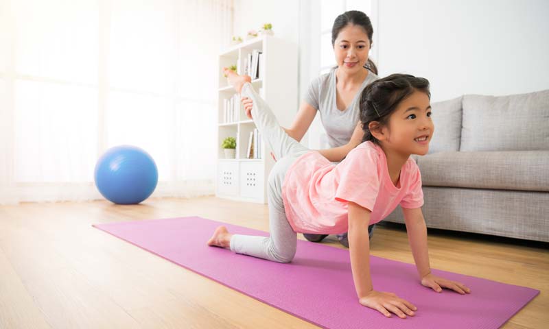 Madre e hija practicando yoga juntas