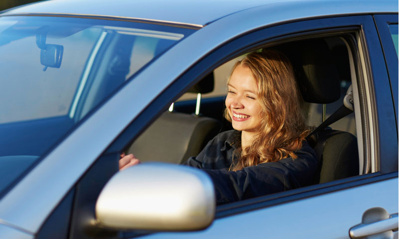 joven y adolescente confiada conduciendo un automóvil