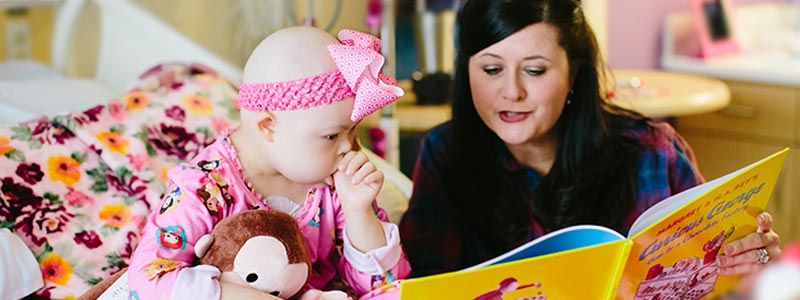 La mamá de Elizabeth le lee un libro mientras está en el hospital. El libro fue una donación de la familia de otro paciente.