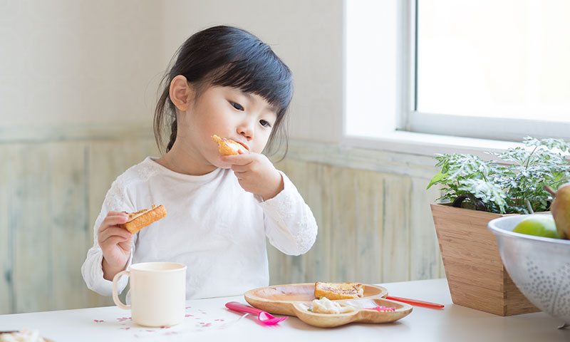 niña pequeña comiendo pan