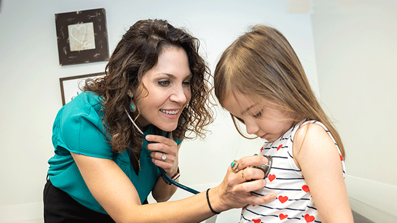 Dr. Christy Glasow, a pediatric cardiologist, listens to her patients heart during the office visit.