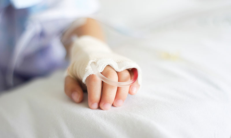 mano de niño con vía intravenosa