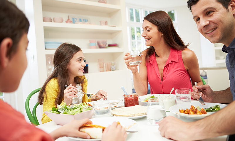 Familia comiendo una comida saludable juntos en la mesa durante la cena
