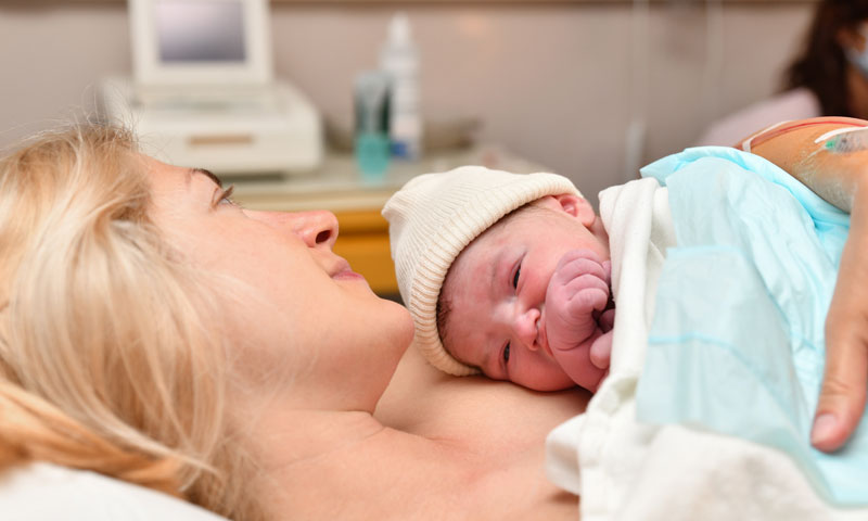 madre sosteniendo a su recién nacido con contacto piel con piel