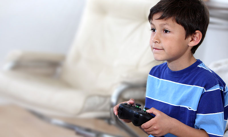 Niño jugando a un videojuego con un controlador de Xbox