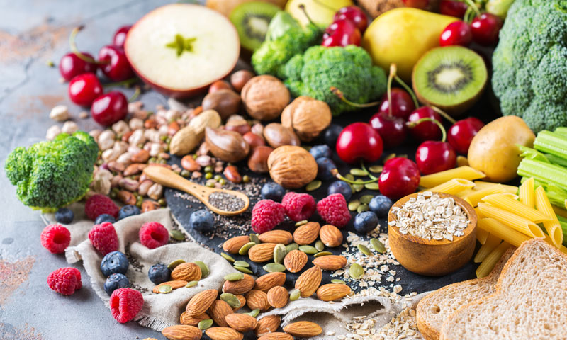 frutas, verduras, frutos secos y granos sobre una mesa
