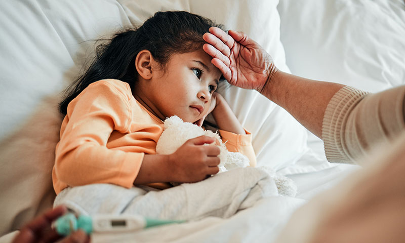 Padre revisando la cabeza de su hija para ver si tiene fiebre.